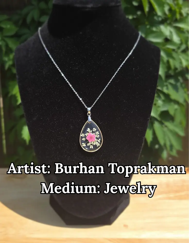 Teardrop resin pendant with pressed pink and white flowers, by Burhan Toprakman