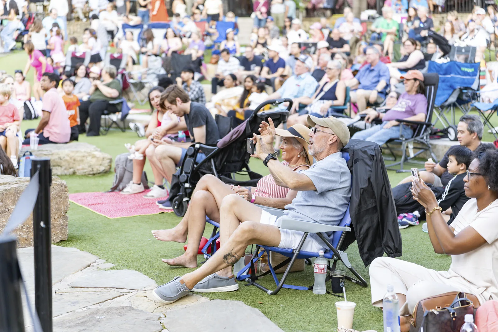 The audience fills the lawn with chairs and blankets during a festival performance